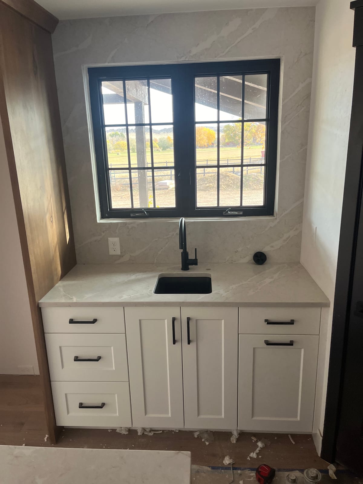 Small undermount sink and matte-black faucet set into a white countertop