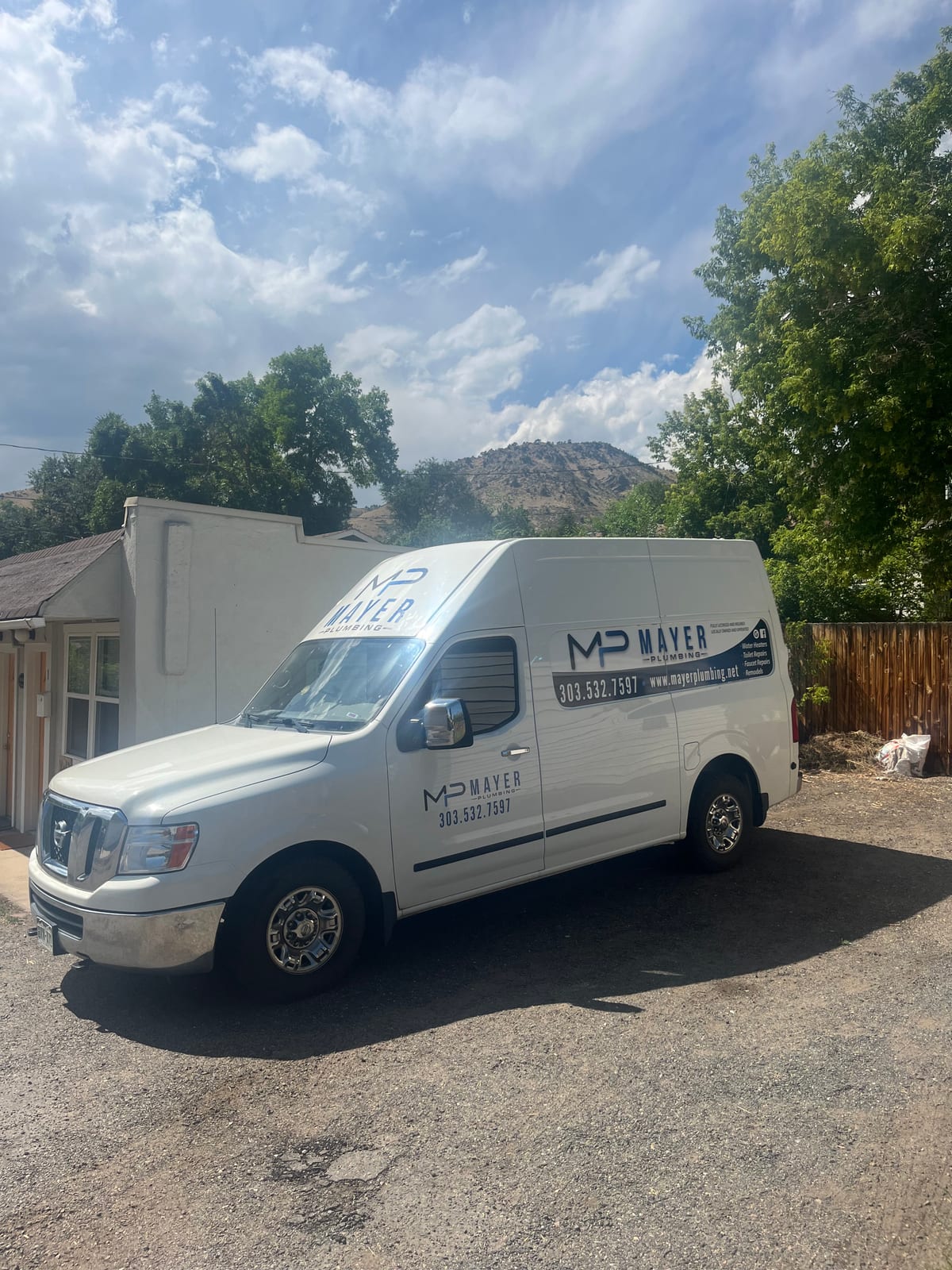 Mayer Plumbing branded service van parked beside a home