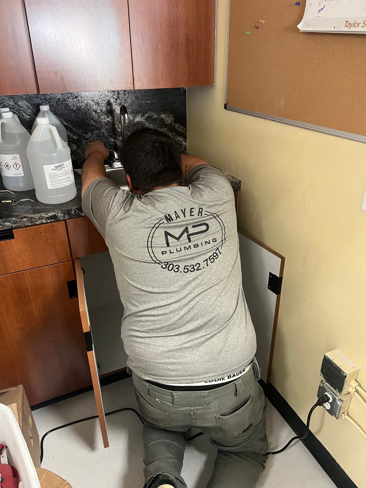 Mayer Plumbing technician working on a sink faucet