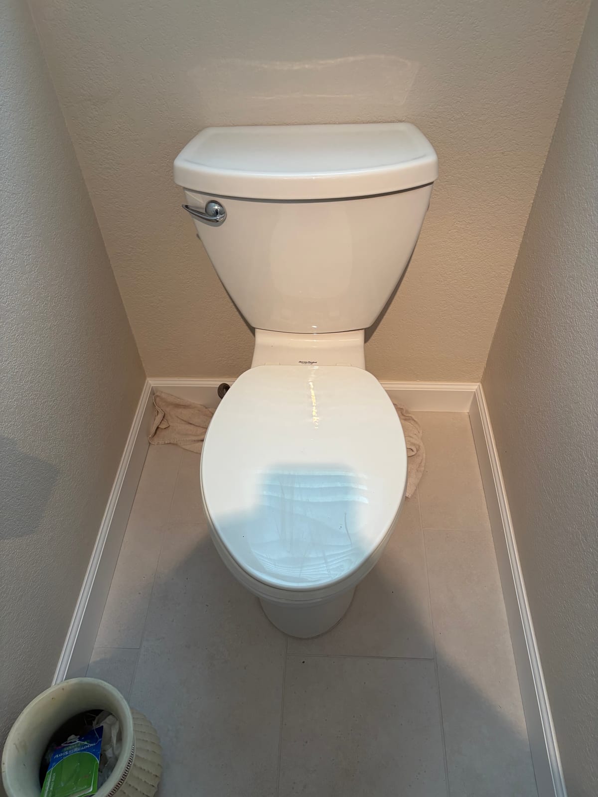 White toilet installed in a residential bathroom alcove