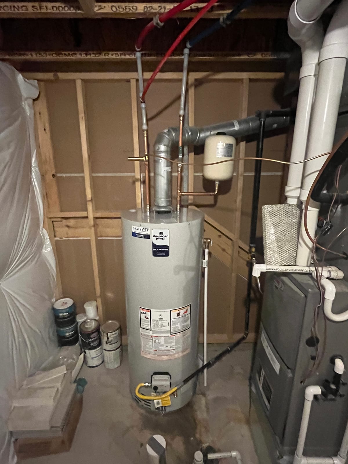 Installed Bradford White gas water heater with expansion tank and vent connections