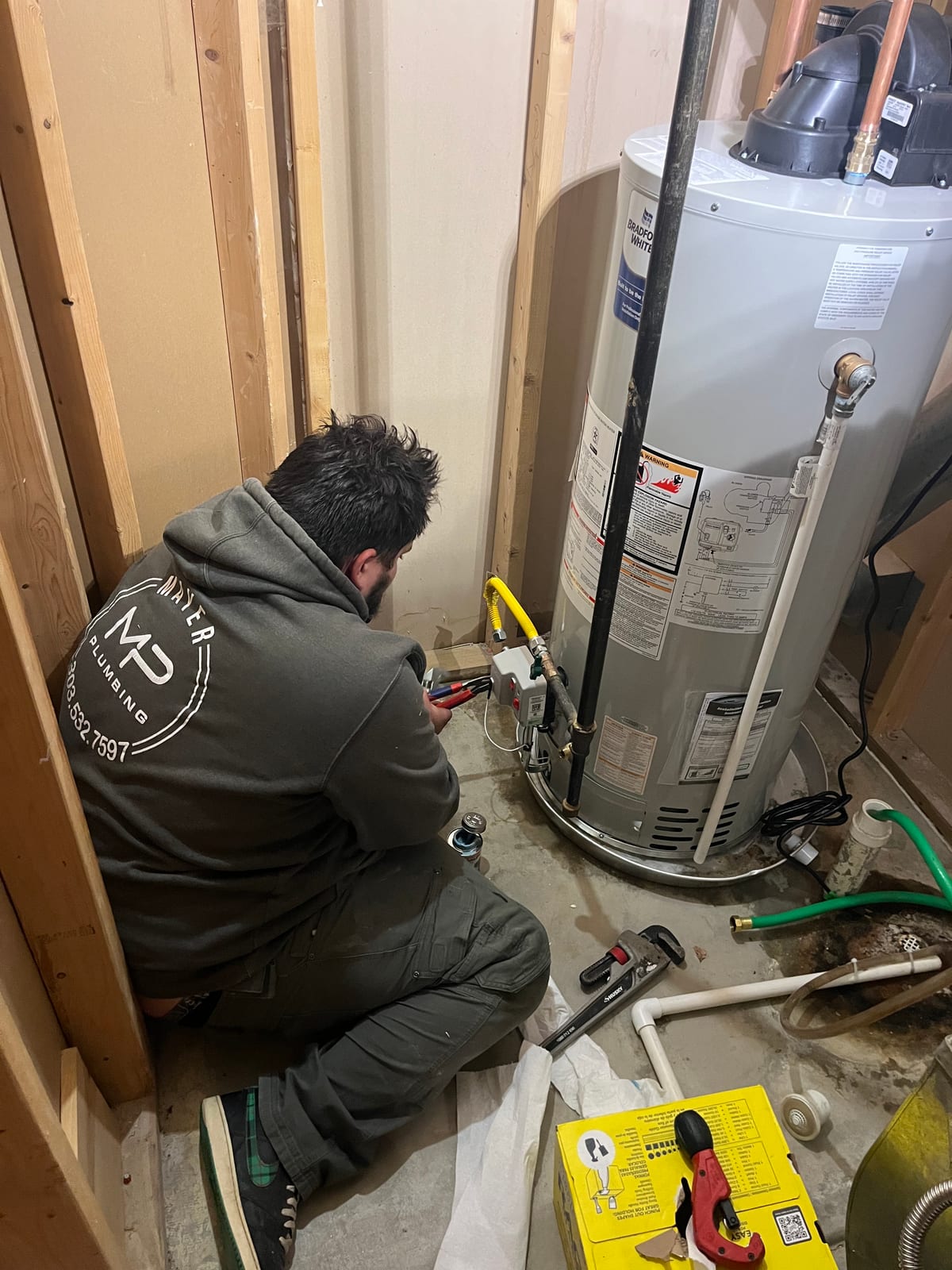 Mayer Plumbing technician servicing a Bradford White tank water heater